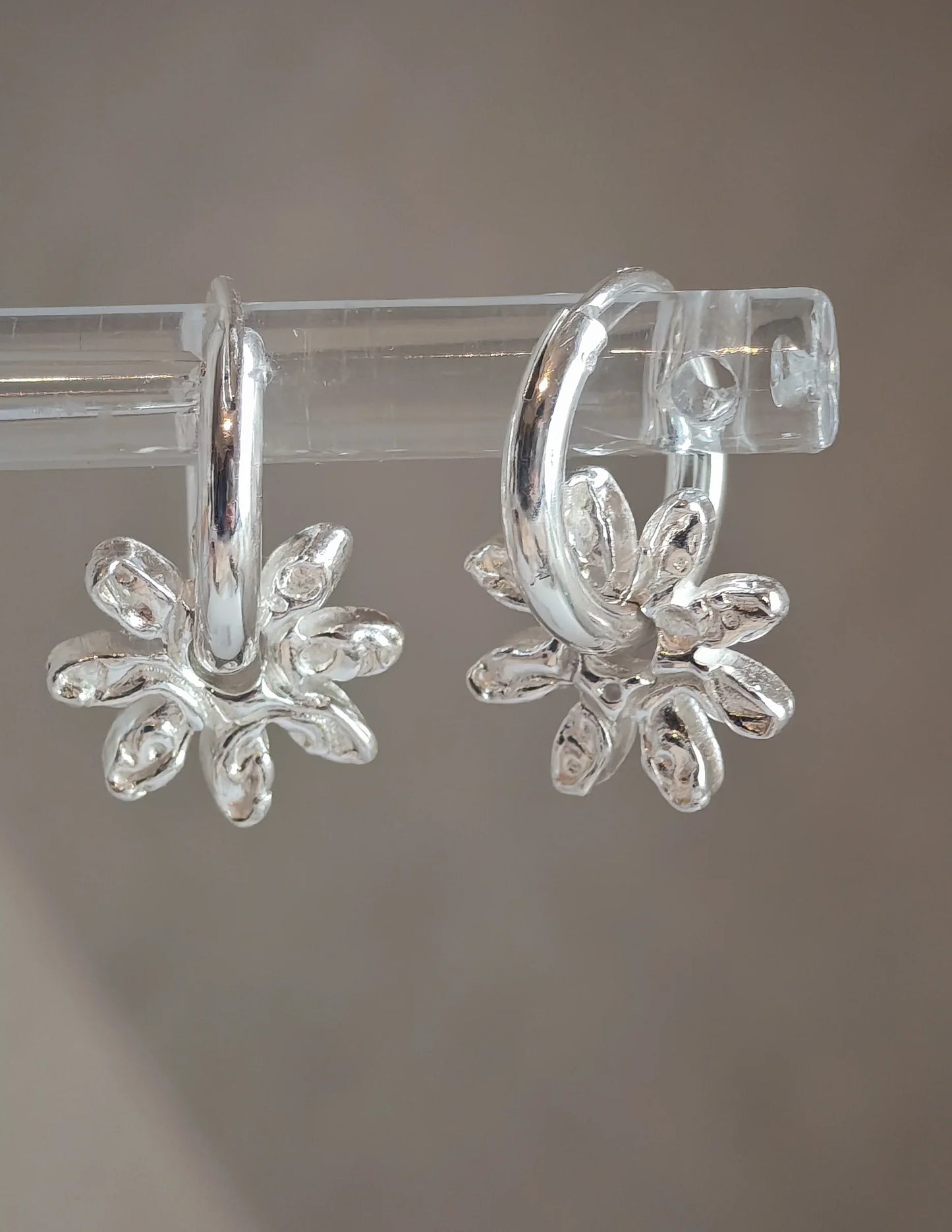 Sterling silver hoop earrings with unique organic petal design against neutral background