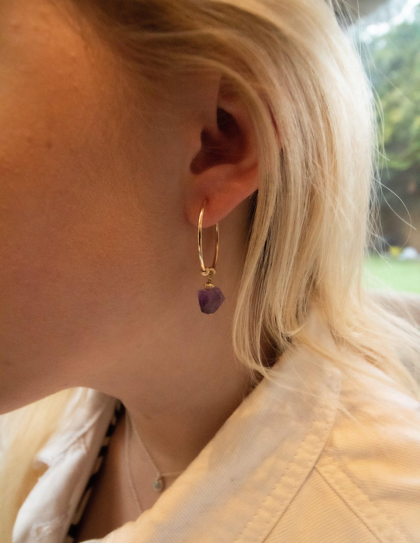 Gold hoop earring with raw amethyst gemstone on ear, handmade gemstone jewelry